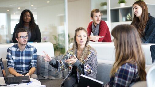 Small group of 6 people listening to a girl talking